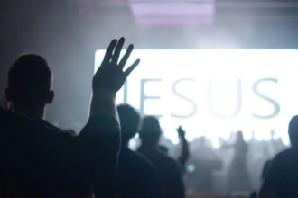 Imagem de pessoas com as mãos para o alto em uma igreja evangélica