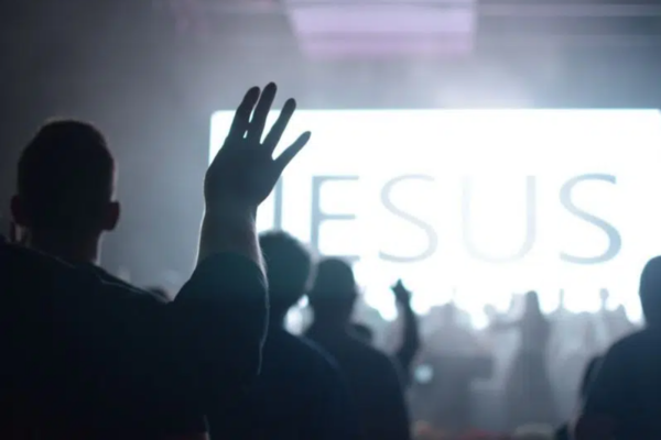 Imagem de pessoas com as mãos para o alto em uma igreja evangélica
