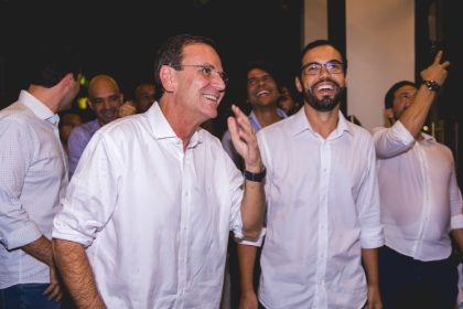 Eduardo Paes e Pedro Duarte sorrindo juntos em evento