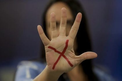 Mulher com um "X" desenhado na mão Pacto Estadual Contra o Feminicídio