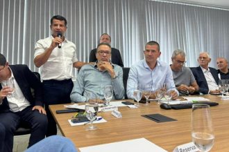 Douglas Ruas, entre o pré-candidato ao Senado Márcio Canella e o vice, Rogério Lisboa, ouvem o discurso do presidente estadual do PP, Dr. Luizinho