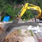 Escavadeira cobre cratera formada à margens da rodovia BR-040, em Petrópolis