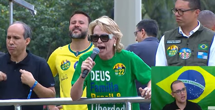 Rogéria Bolsonaro discursa e tenta animar o público que esperava seu filho, Flávio, na Praia de Copacabana