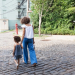 Mãe e filha andando de mãos dadas na rua