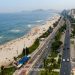 Imagem aérea de praia na Barra da Tijuca, com quiosques na orla