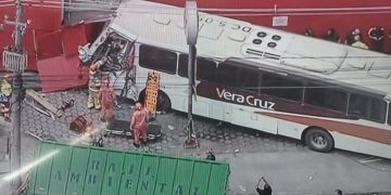 Ônibus bateu em caminhão, perdeu o controle e atingiu parede de fábrica de malhas